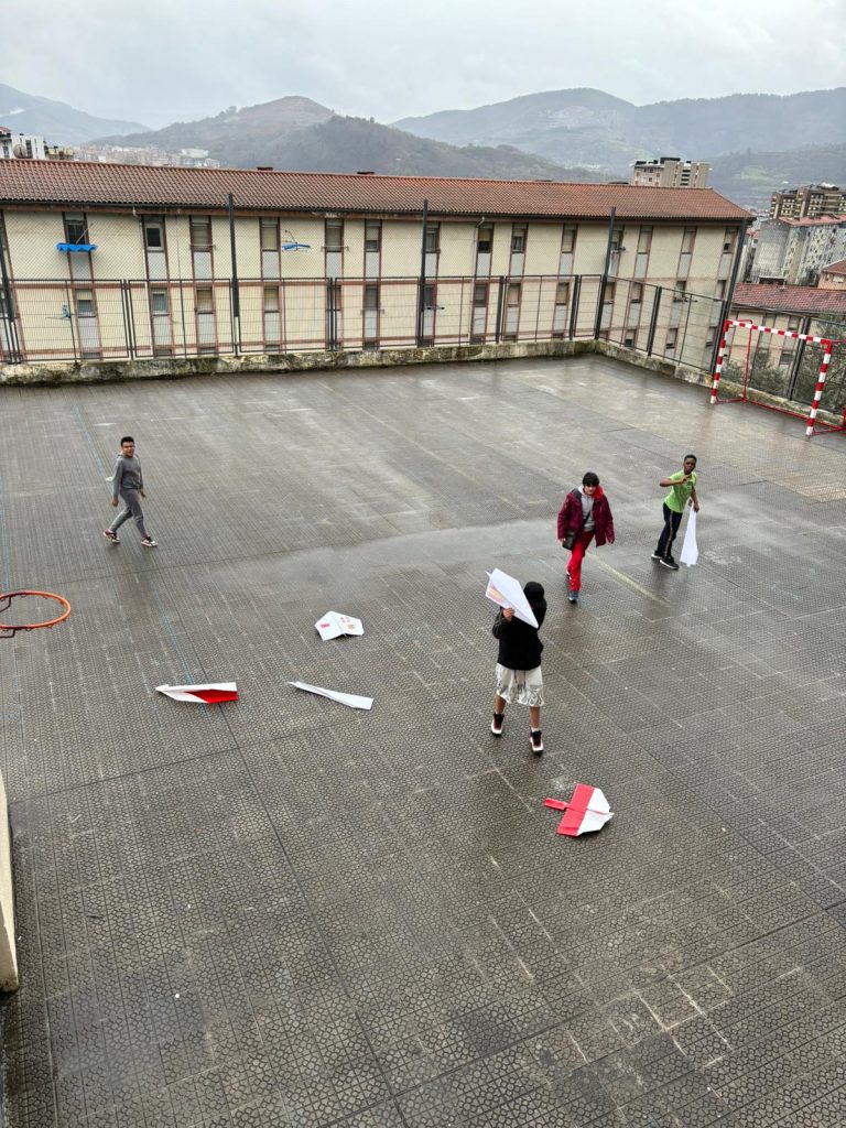 Alumnos jugando en el patio con los aviones